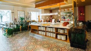 A modern kitchen with a central island, shelves with kitchenware, and a patterned floor.