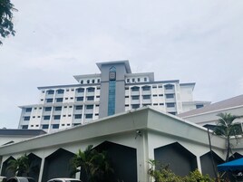 A multi-story building with a central tower and a flat roof.