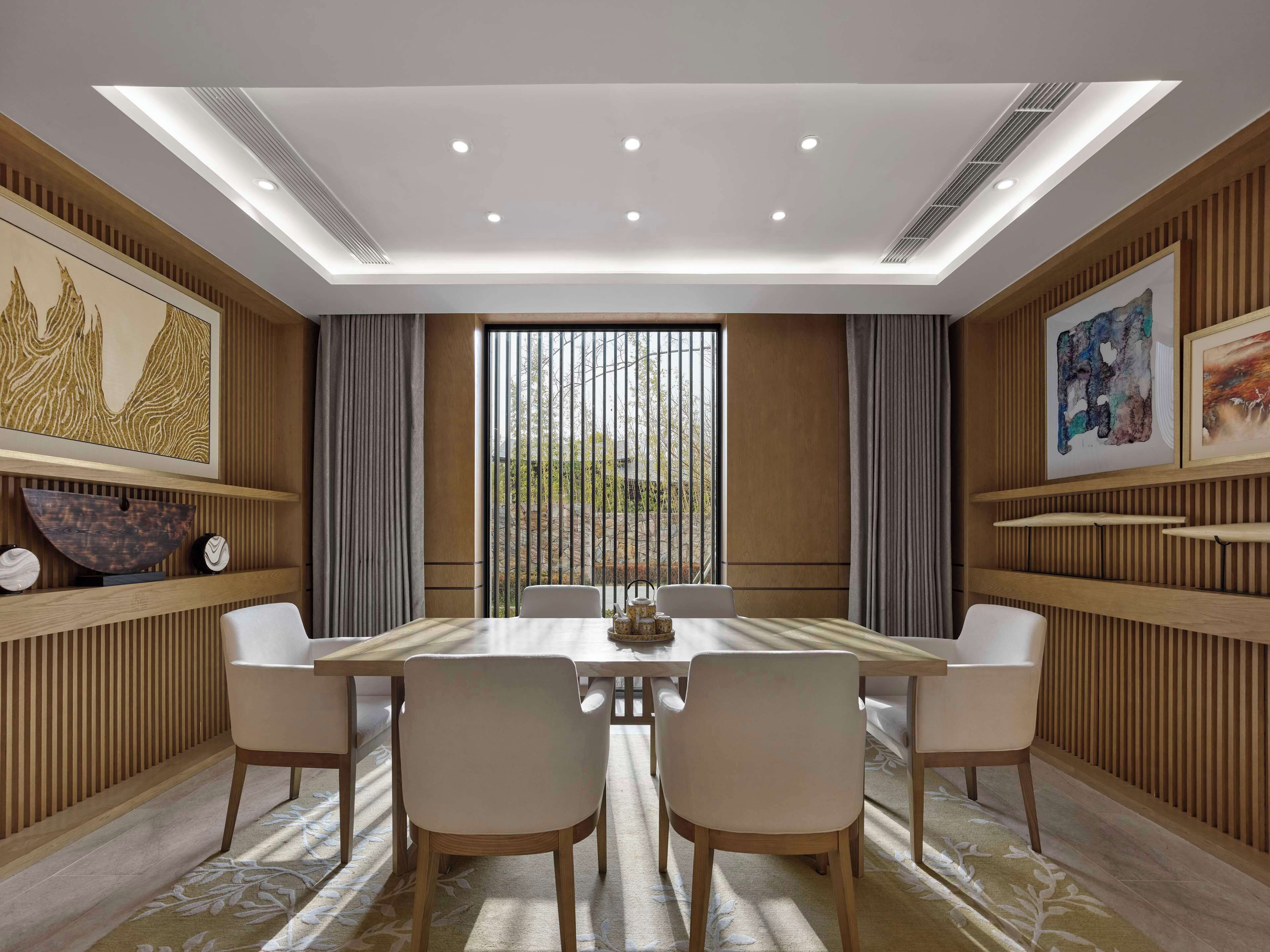 Un comedor moderno con una mesa grande, cuatro sillas y vistas a través de una ventana con persianas verticales.