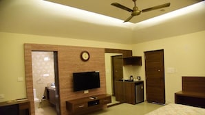 A hotel room with a bed, a TV, a desk, a wardrobe, and a bathroom. - The International Centre Goa (Panaji)