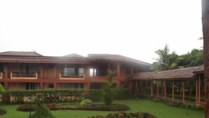 A two-story building with a flat roof and a covered outdoor area. - The International Centre Goa (Panaji)