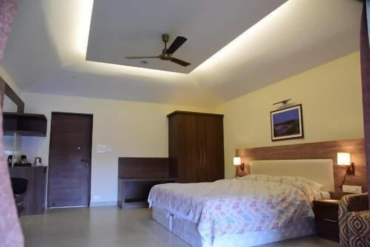 Un dormitorio con cama, armario, ventilador de techo y mesita de noche.