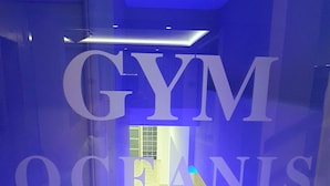 Un pasillo con un letrero que dice "GYM OCEANIS" que conduce a una habitación luminosa.