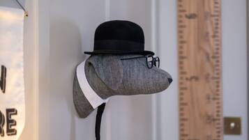 A head-shaped sculpture with a black hat and glasses, mounted on a wall.