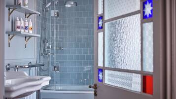 A bathroom with a shower, a sink, and shelves with toiletries.