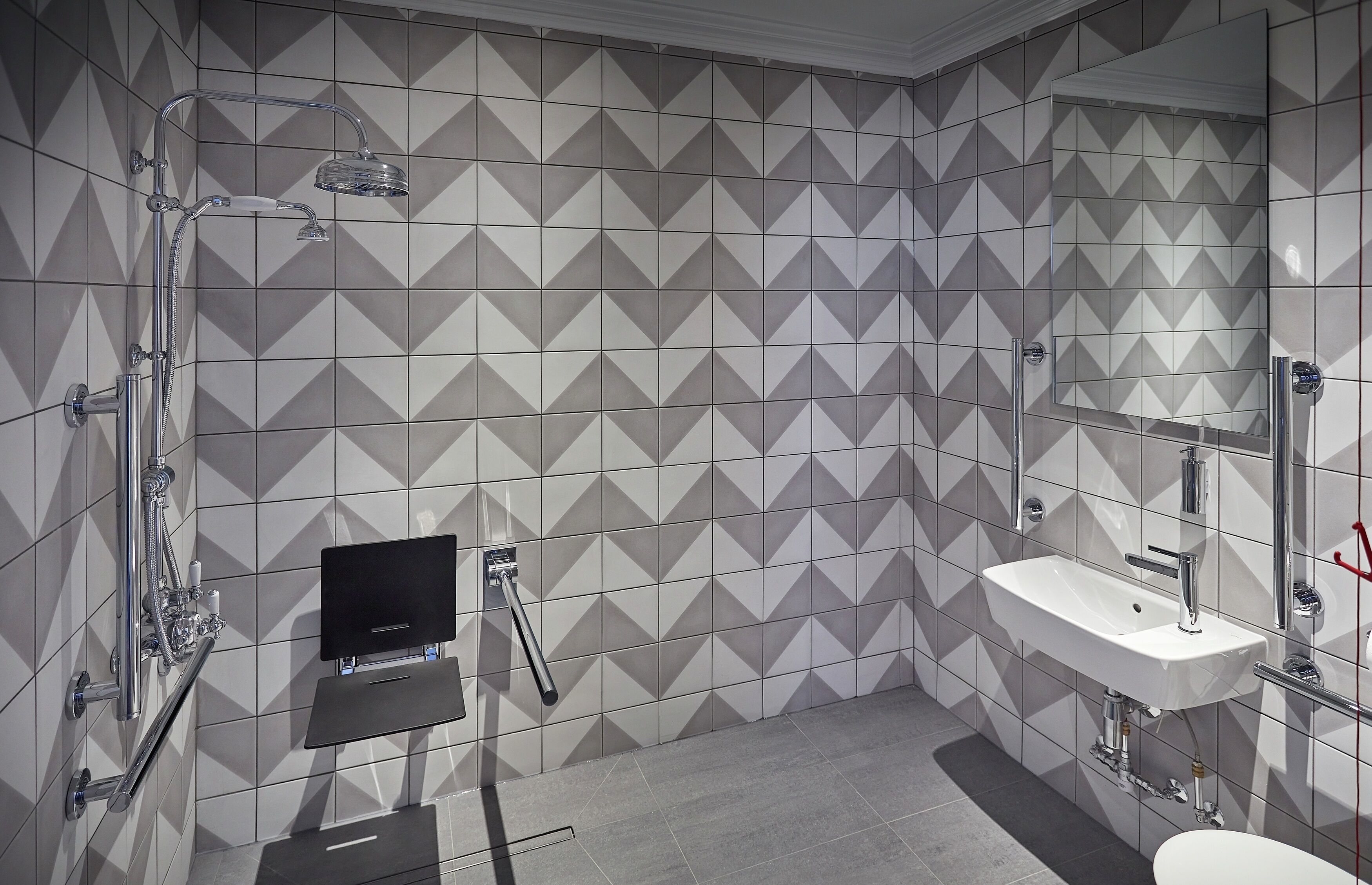 A modern bathroom with a shower, a sink, and a mirror.