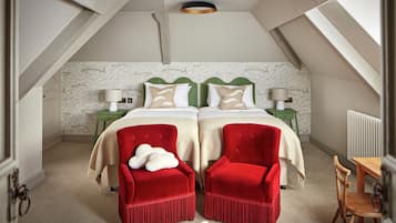 Un dormitorio con una cama doble, dos mesitas de noche, una silla roja, una silla de madera y un radiador.