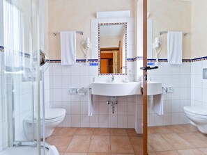 Habitación estándar doble | Baño | Ducha, secador de pelo y toallas