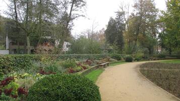 Un camí de jardí amb bancs i diverses plantes.