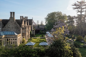 A historic building with a courtyard, outdoor seating, and a garden.