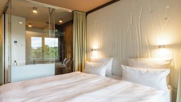 Habitación de hotel con una cama grande, un espejo y dos luces fijadas a la pared.