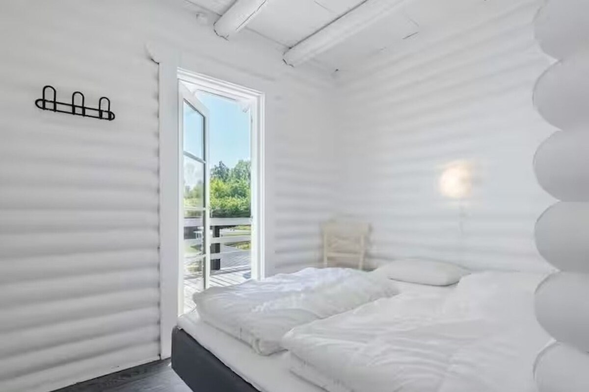 A room with a bed, a window, and a door leading to an outdoor area.