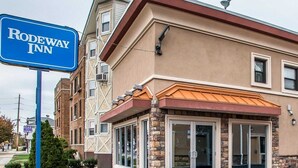 Edificio di un Rodeway Inn con facciata beige, dettagli in pietra e ampie porte in vetro.