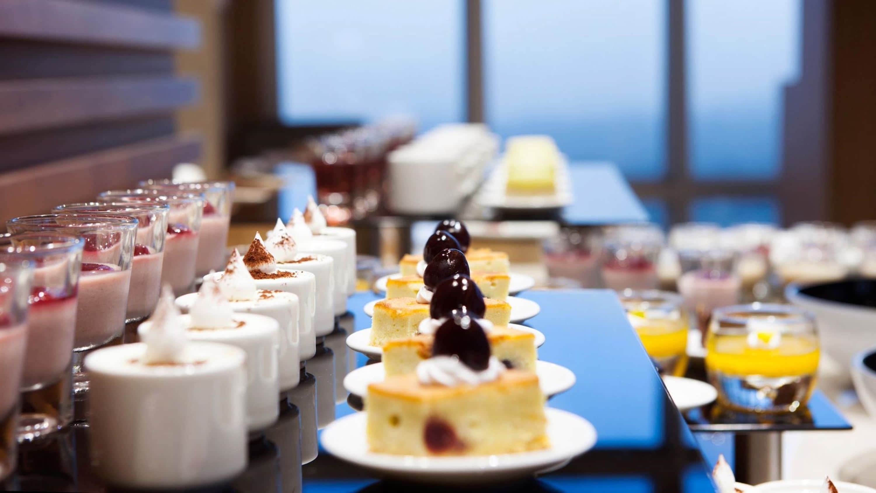 Un buffet proposant une variété de desserts, notamment des gâteaux et des tartes aux fruits.