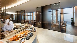 A modern restaurant with a seafood display, large windows, and a view of the city.