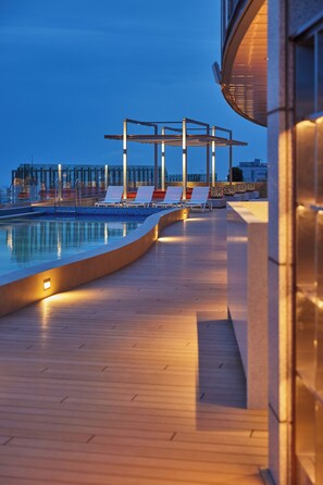 A rooftop pool area with lounge chairs and a pergola structure. - LOTTE CITY HOTEL JEJU AIRPORT (Jeju City)