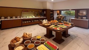A spacious kitchen with a buffet setup, featuring a variety of food items and a large window providing a view. - Taxim Express (Istanbul)