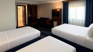 A hotel room with two single beds, a desk, a chair, and a TV. - Taxim Express (Istanbul)