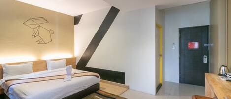 Una habitación de hotel moderna con una cama grande, un escritorio y una silla.
