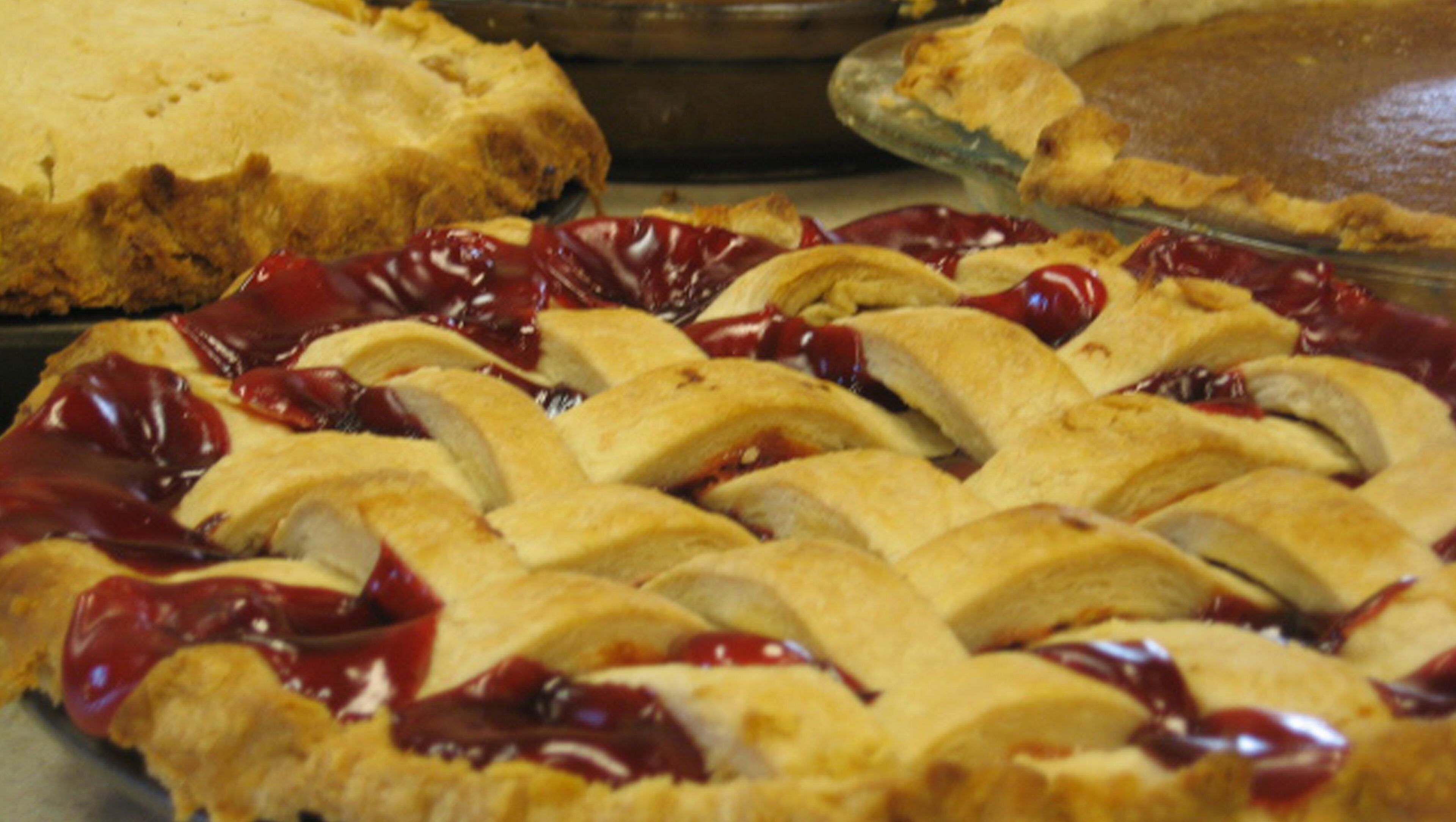 Une tarte avec une pâte en croisillons et une garniture aux cerises.