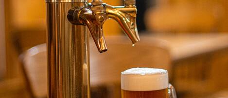 A tap with beer flowing into a glass.