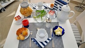 A breakfast table set with a teapot, cups, plates, and a jar of food. - Agli Horti Sallustiani bed & breakfast (Rome)