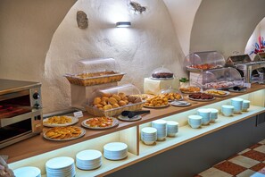 Un bufé con diversas opciones de comida y una estación de café de servicio propio.