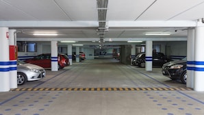 Un estacionamiento con varios niveles y varios coches aparcados.