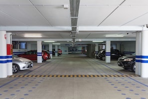 A multi-level parking garage with several cars parked. - Hotel Portici Romantik & Wellness (Riva del Garda)