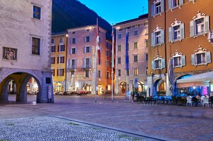 A historic square with cobblestone pavement, traditional European architecture, and outdoor seating areas.