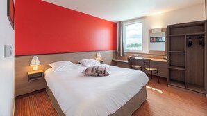 A hotel room with a large bed, a desk, a chair, a wardrobe, and a window with a view of the outdoors. - ACE Hôtel Châteauroux Déols (Deols)