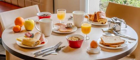 A breakfast table with various food items, including toast, eggs, and juice.