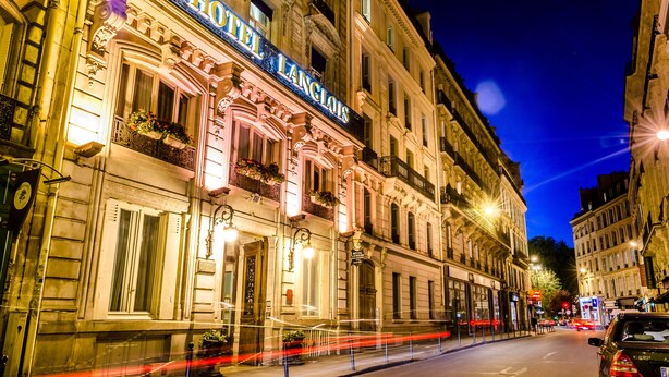 A historic building with ornate architecture, a prominent sign reading "HOTEL L'ANGLOIS," and a street view with a car and light trails. - Hotel Langlois (Paris)