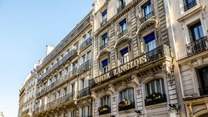 A multi-story hotel with ornate balconies and large windows. - Hotel Langlois (Paris)