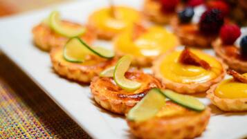 A plate of mini quiches with fruit toppings.