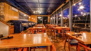 A restaurant with wooden tables and booths, large windows, and a chandelier. - Best Western Plus Rivershore Hotel (Oregon City)