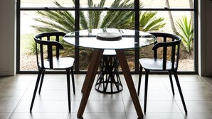 A dining area with a round table and four chairs, large windows with a view of greenery, and a hanging light fixture. - Alure Stanthorpe (Mount Tully)