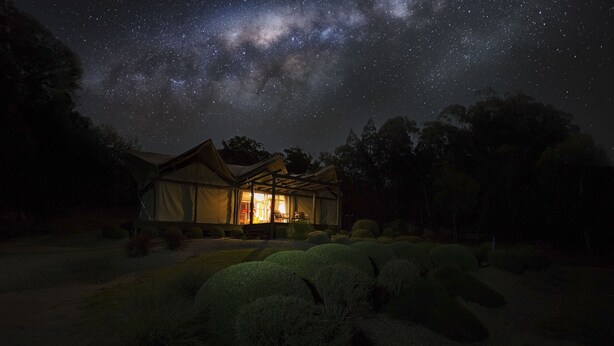 A tented accommodation with a view of the night sky, surrounded by well-maintained shrubbery. - Alure Stanthorpe (Mount Tully)