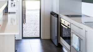A modern kitchen with a dishwasher, oven, and a built-in sink. - Alure Stanthorpe (Mount Tully)