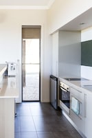 A modern kitchen with a dishwasher, oven, and a built-in sink.