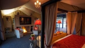 A spacious bedroom with a large bed, a fireplace, and a view of the outdoors. - Alure Stanthorpe (Mount Tully)