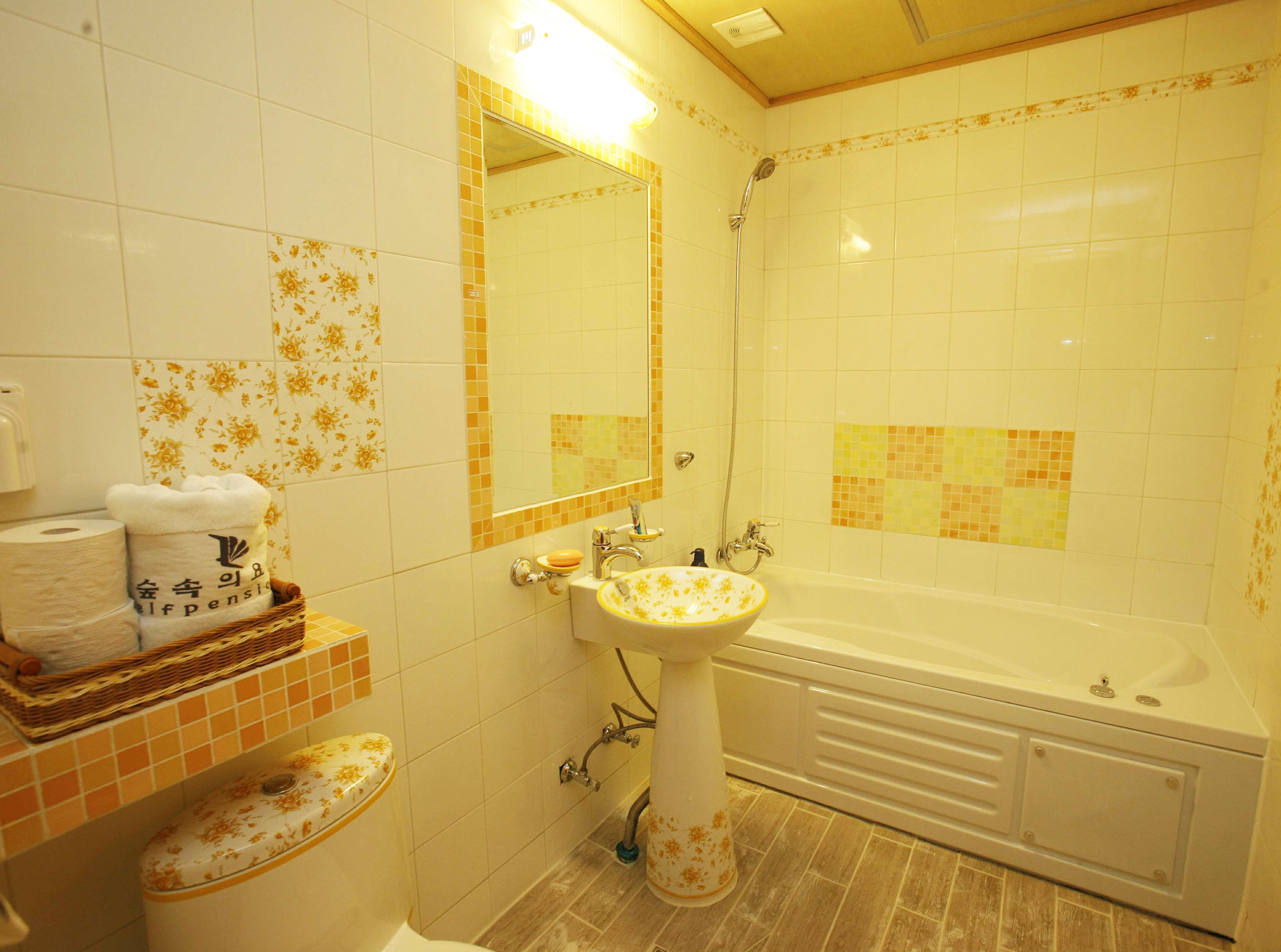 A bathroom with a bathtub, a sink, a toilet, and a mirror.