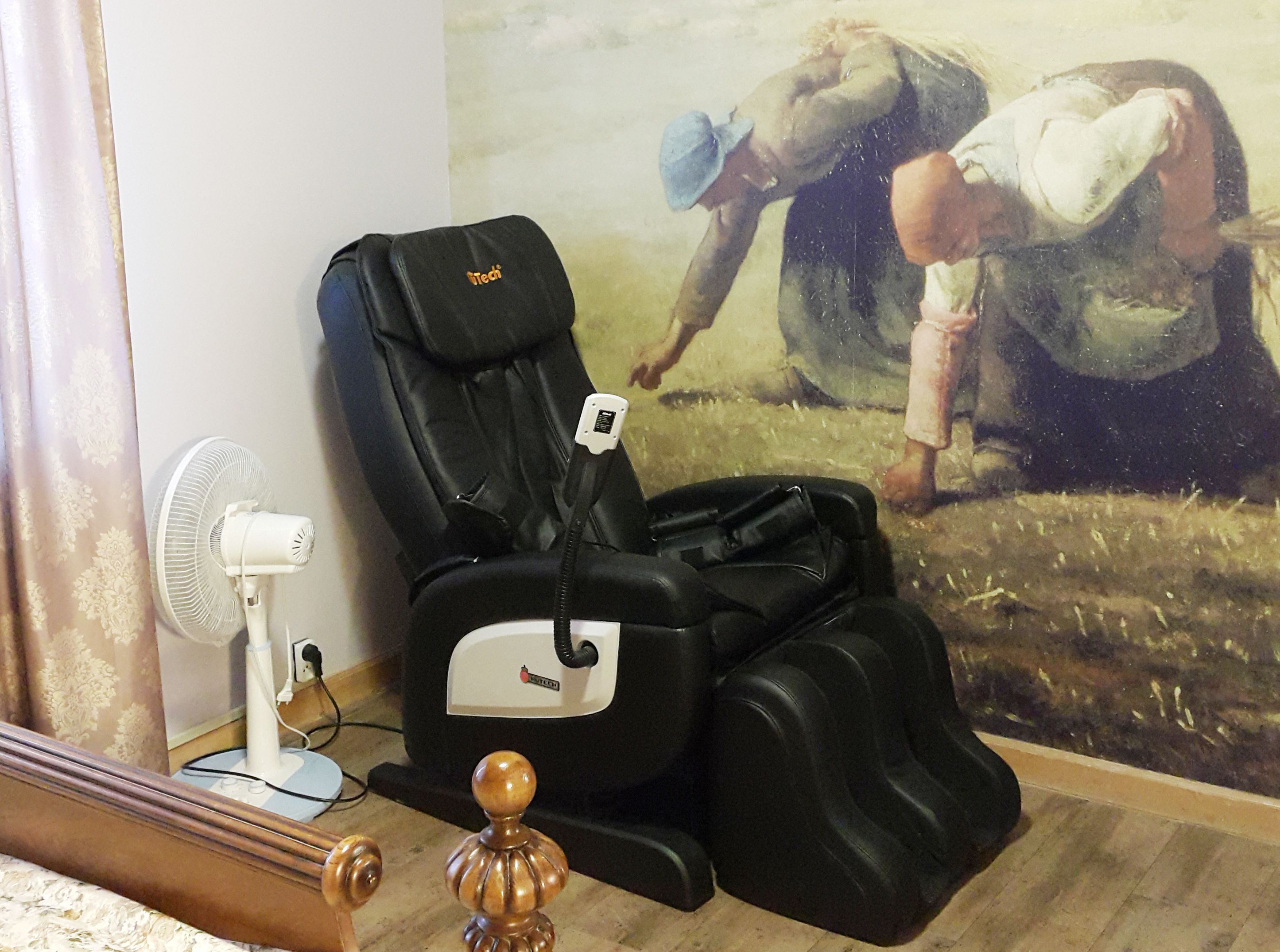 Un fauteuil de massage doté d’un panneau de commande, d’un ventilateur blanc et d’un objet décoratif en bois.