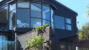 A modern building with large windows and a wooden staircase.