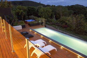 Relax by the pool surrounded by lush greenery and enjoy a soak in the hot tub.