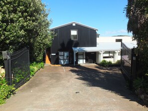 Enter through the black metal gate and step into a commercial property surrounded by lush greenery.
