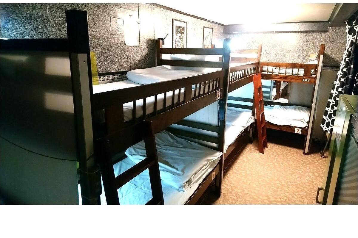 A bunk bed room with a tiled wall and a small window.