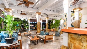 A spacious lobby with a high ceiling, wooden furniture, and potted plants. - Villa Almarik (Gili Trawangan)