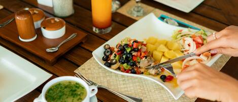 A dining table with various dishes, including a salad, soup, and a fruit plate.