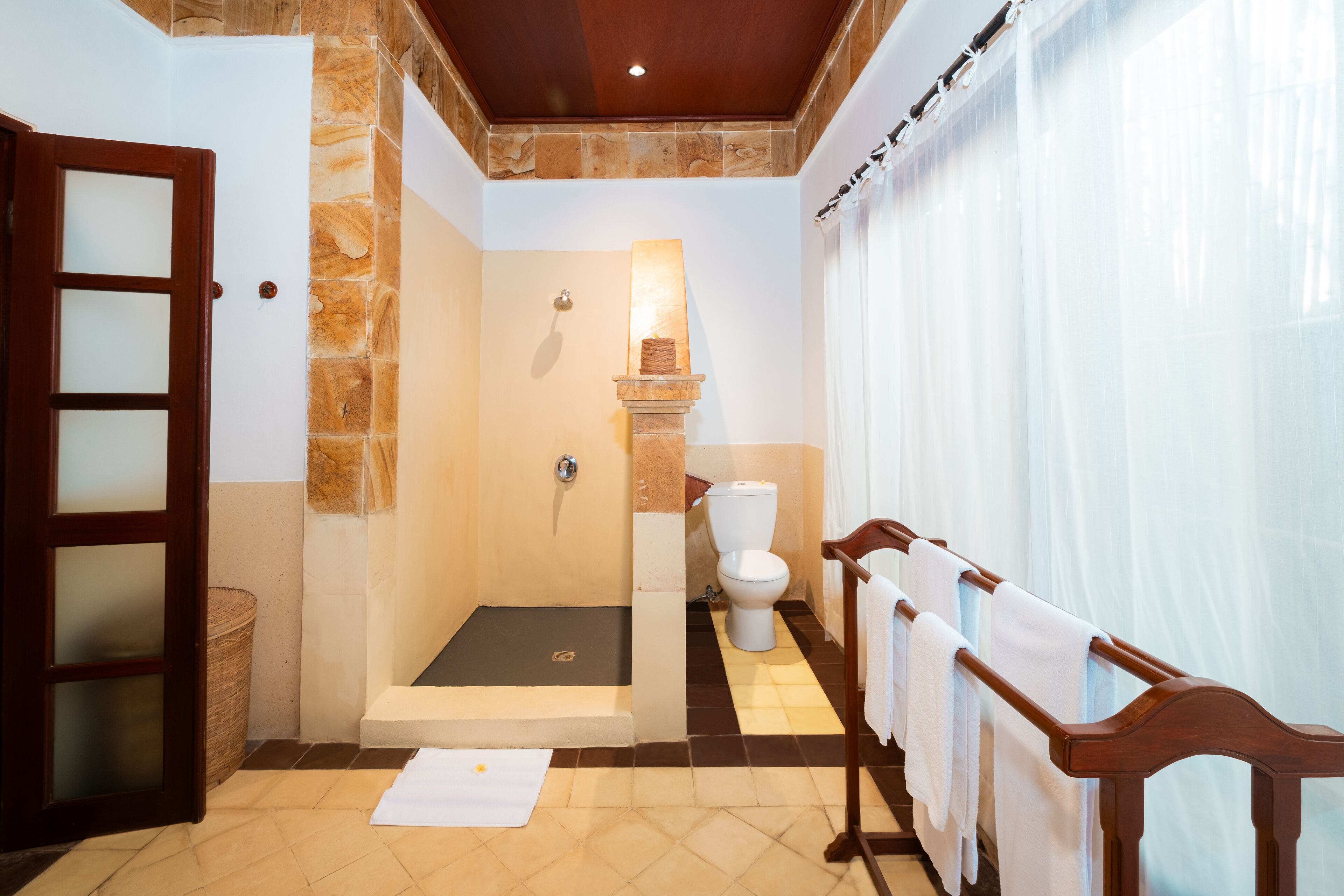 A bathroom with a shower, toilet, and a towel rack.